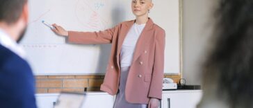 bald woman near whiteboard with charts